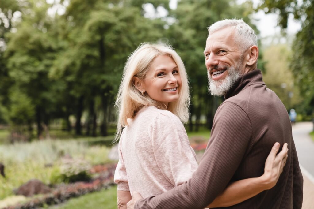 Mature spouses hugging embracing walking on a date in park together. Bonding, love and relationship